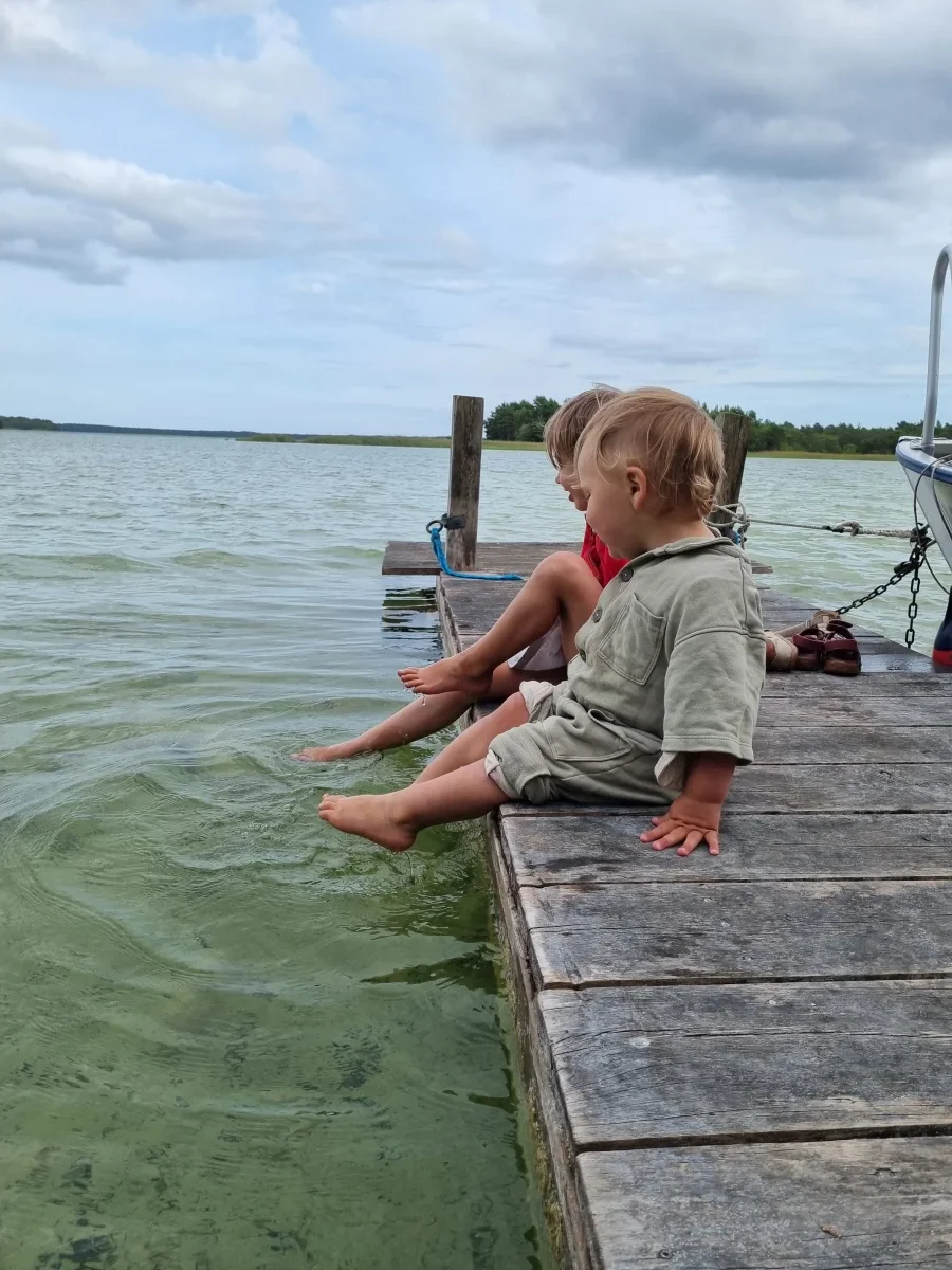 Barn plaskar med fötterna i det klara vattnet i Bästeträsk