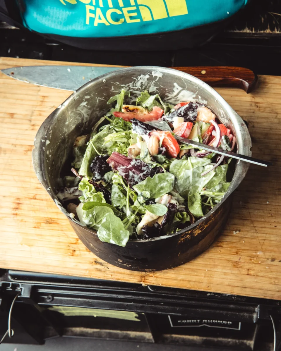 Sallad blandad i en kastrull på campingen