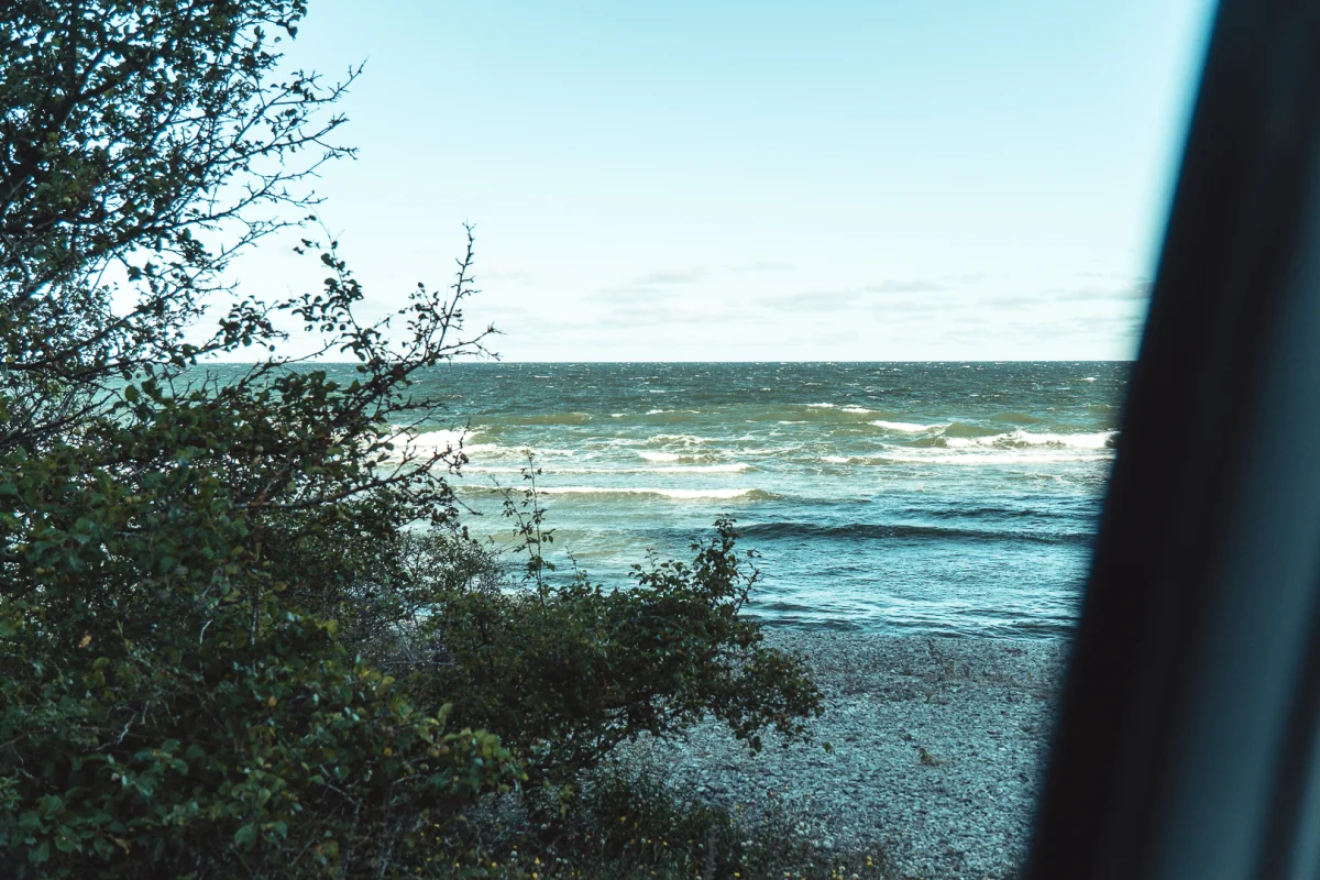 Blåsigt hav med vita vågor sett genom bilrutan en morgon på Gotland