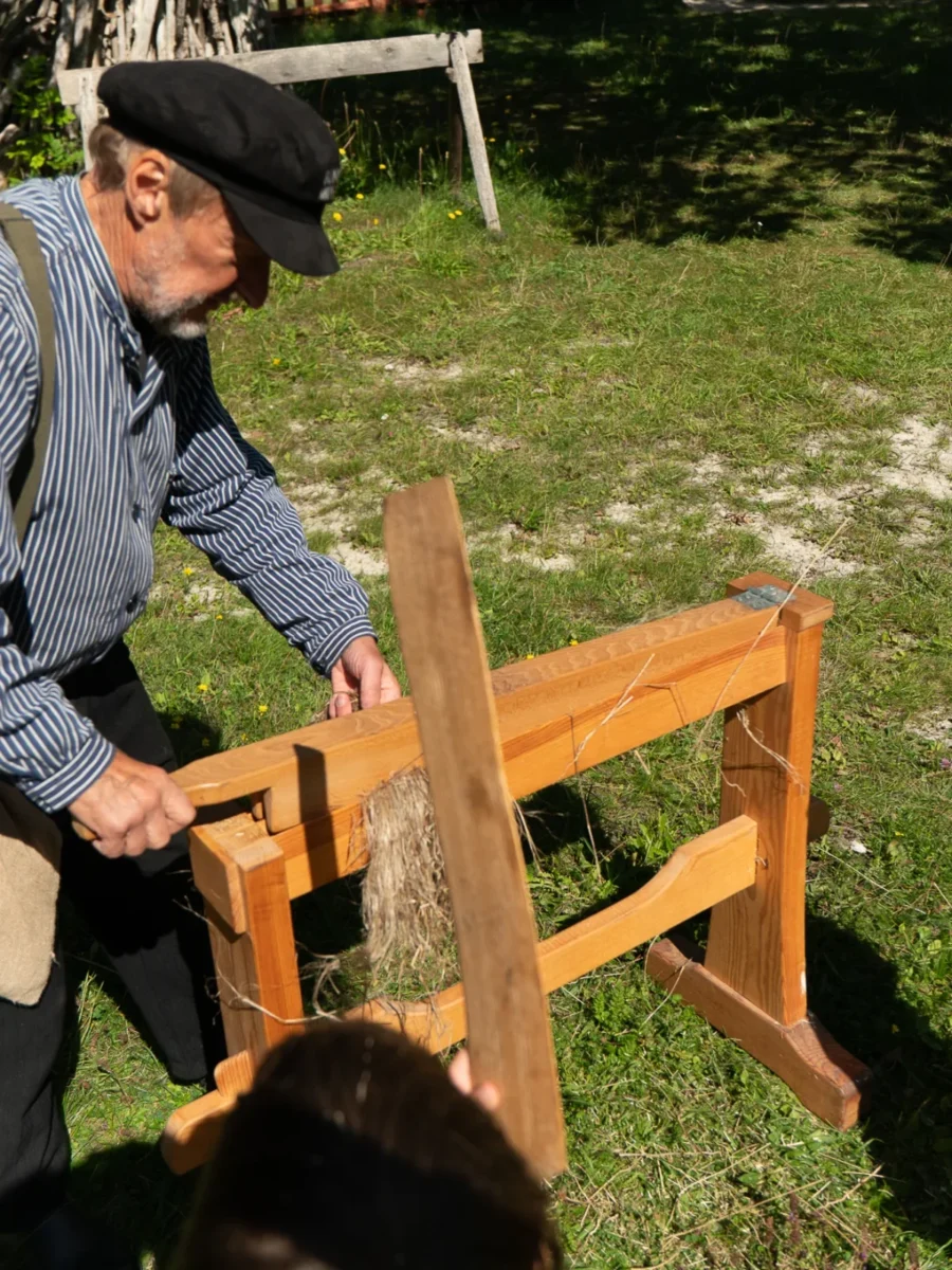 Man i keps visar hur en linbråka fungerar på Bungemuseet