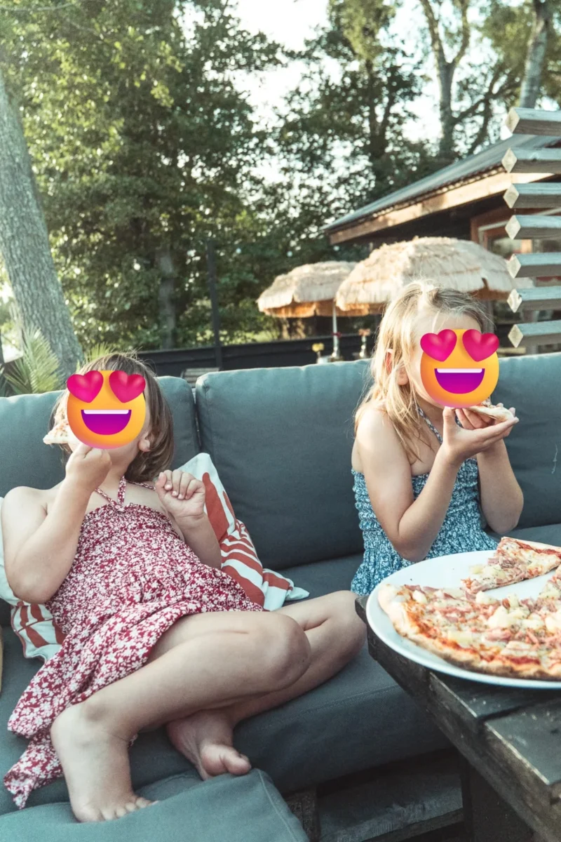Barnen äter pizza i soffan på Strandkaféet vid Sudersand