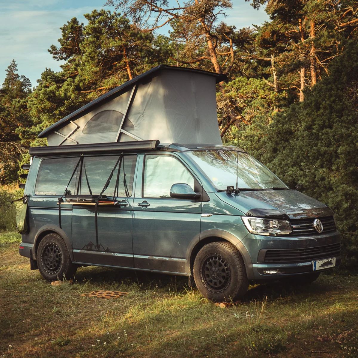 vw californina campingbil med poptop uppfäld i naturen